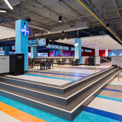 Tables, chairs and steps to a lounge space at Round1