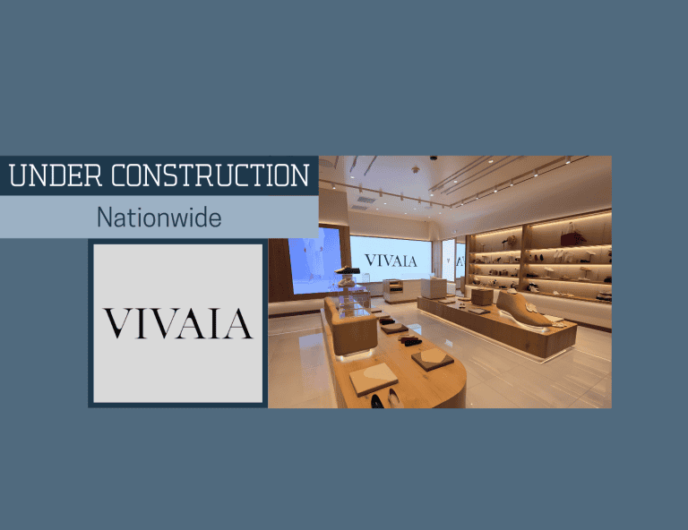 Interior view of a store under construction with shelves, seating, and a large screen displaying 'VIVAIA'.
